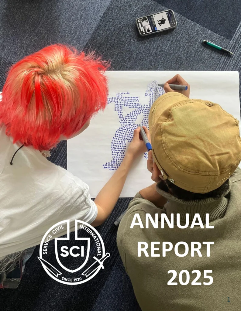 Cover of the SCI Annual Report 2025: two young people, one with bright red hair, drawing a map with blue pens on a large sheet of paper on the floor.